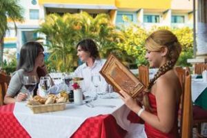 woman reviewing menu at one of the multiple restaurants to choose from at the cheap, all-inclusive Fiesta Americana Holguin Costa Verde resort in Cuba